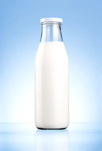Fles verse melk geïsoleerd op een blauwe achtergrond — Stockfoto