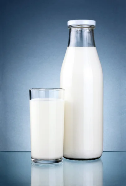 Botella de leche fresca y un vaso aislado sobre un fondo gris oscuro — Foto de Stock