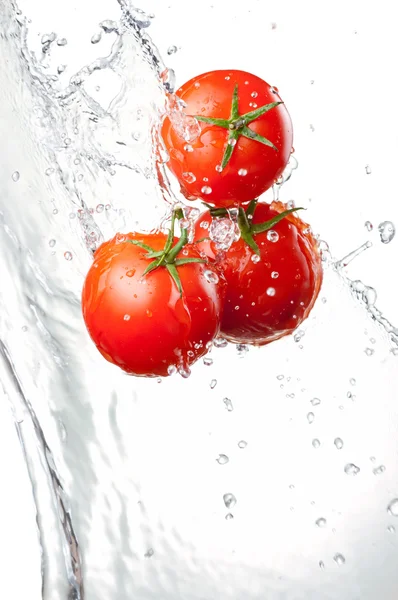Trzy świeże czerwone pomidory w plusk wody na białym tle biały ba — Zdjęcie stockowe