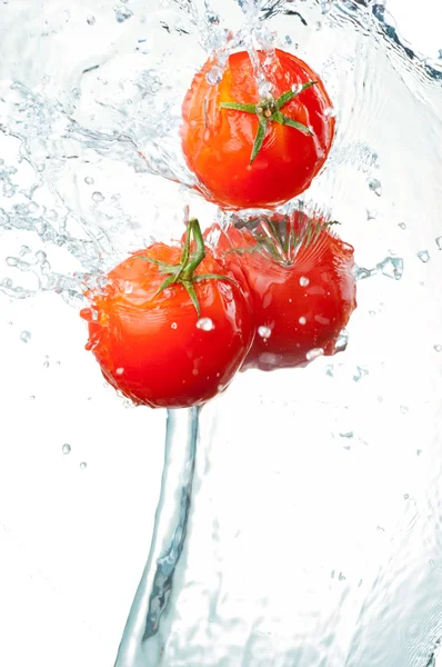 三个新鲜红番茄中飞溅的水隔离上白 ba — 图库照片