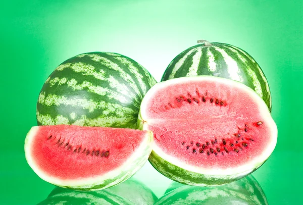 Two watermelon, half and Slice on a green background — Stock Photo, Image