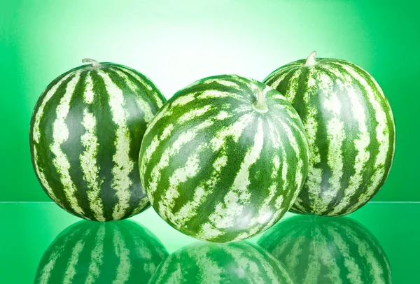 Tre vattenmeloner isolerad på en grön bakgrund — Stockfoto