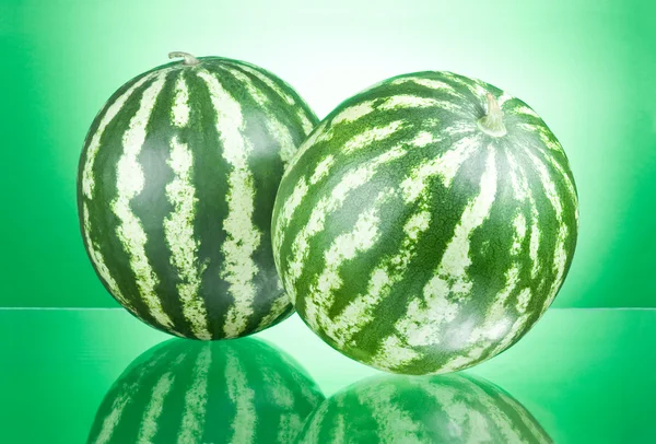 Två vattenmeloner isolerad på en grön bakgrund — Stockfoto