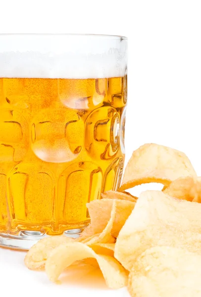 Кружка свежего пива крупным планом и куча картофельных чипсов — стоковое фото