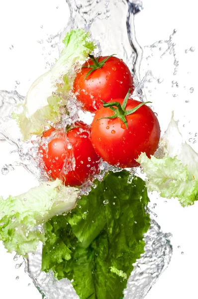 Trzy czerwone pomidory świeże i sałata w plusk wody na tle — Zdjęcie stockowe