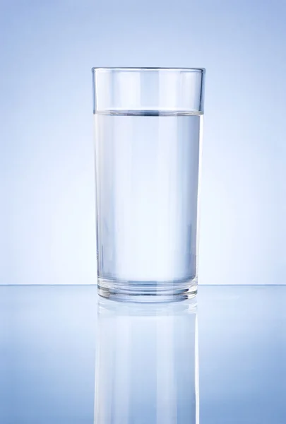Glas Wasser auf blauem Hintergrund — Stockfoto