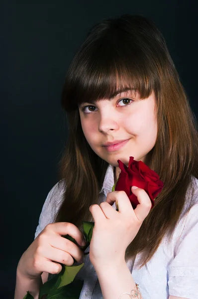 Menina com uma rosa em um fundo preto — Fotografia de Stock