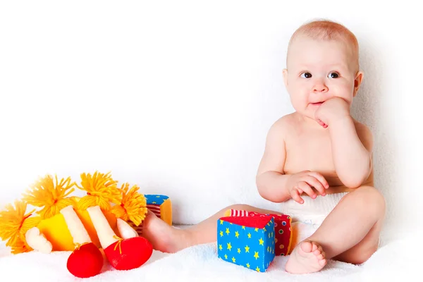 Das sitzende Kind mit Spielzeug — Stockfoto