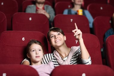 A girl with mother at the cinema clipart