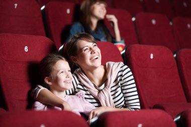 Loughing mother and daughter at the cinema clipart