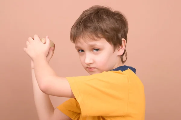 年轻的男孩扔一个球 — 图库照片