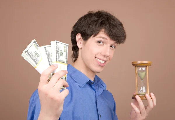 Young businessman with sand-glass and money — Stock Photo, Image