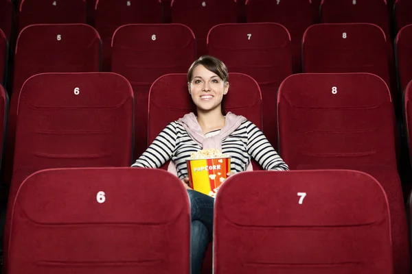 Giovane donna con popcorn nel cinema — Foto Stock
