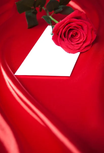 信封和红玫瑰丝绸或缎背景 — 图库照片