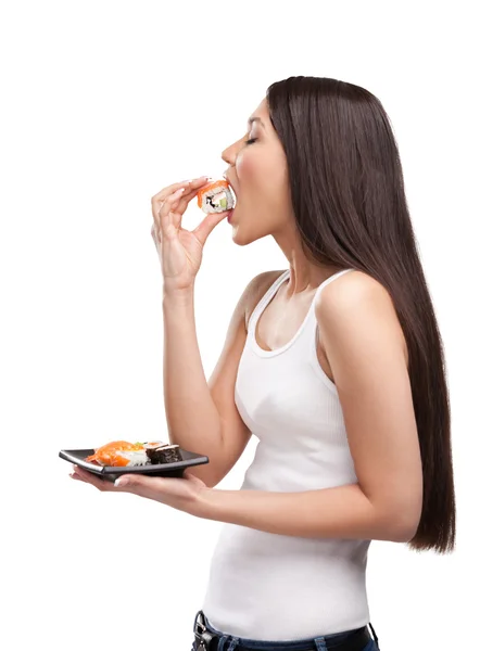 Chica joven comiendo sushi, vista de perfil — Foto de Stock