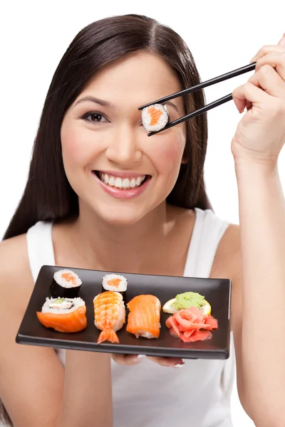 Χαμογελαστή γυναίκα που κρατά ρολό σούσι με ένα τσοπ στικς — Φωτογραφία Αρχείου