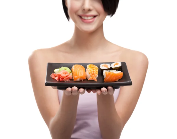 Jovencita sosteniendo plato de sushi y sonriendo — Foto de Stock