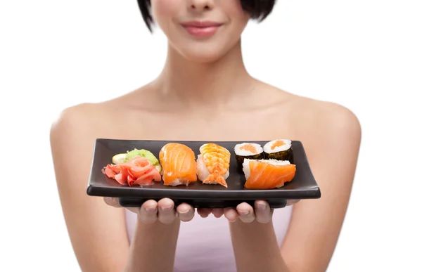 Νεαρή κοπέλα που κρατά πιάτο σούσι — Φωτογραφία Αρχείου