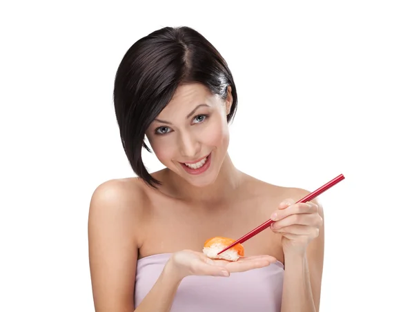Leende ung kvinna håller sushi med en pinnar — Stockfoto