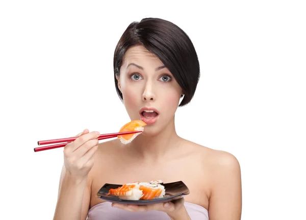 Mujer joven sorprendida sosteniendo sushi con palillos — Foto de Stock