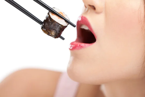 Красивая девушка держит суши палочками для еды, крупным планом — стоковое фото