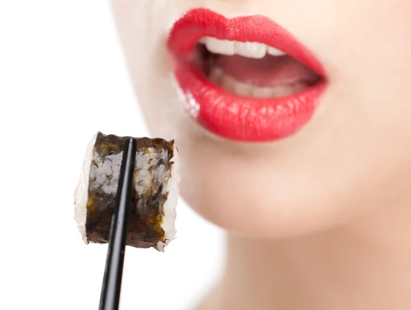 Brunett kvinna med sushi med en pinnar, närbild — Stockfoto