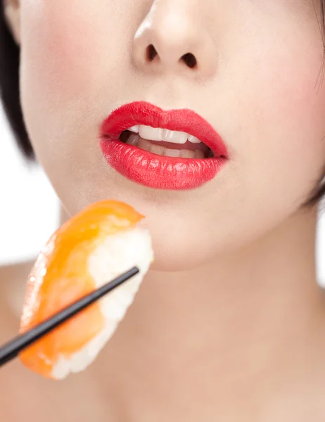 Donna attraente che tiene il sushi con le bacchette, primo piano — Foto Stock