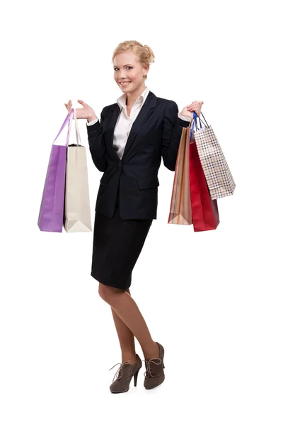 Mulher de negócios loira em um terno preto segurando sacos de compras — Fotografia de Stock