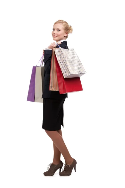 Jovem mulher de negócios em um terno preto segurando sacos de compras, retrato de comprimento total — Fotografia de Stock