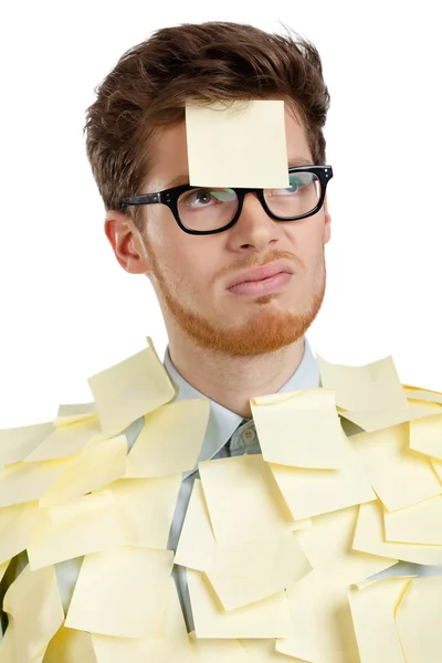 Unhappy young man with a sticky note on his face, covered with yellow stickers — Stock Photo, Image