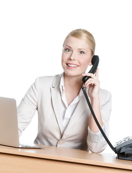 Telefon ahizesi ile office masada oturan genç iş kadını — Stok fotoğraf