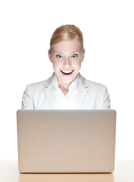 Jovem empresária feliz sentada em uma mesa de escritório com laptop — Fotografia de Stock