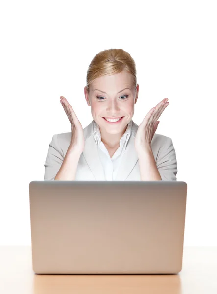 Glad ung affärskvinna som sitter vid ett skrivbord med laptop — Stockfoto