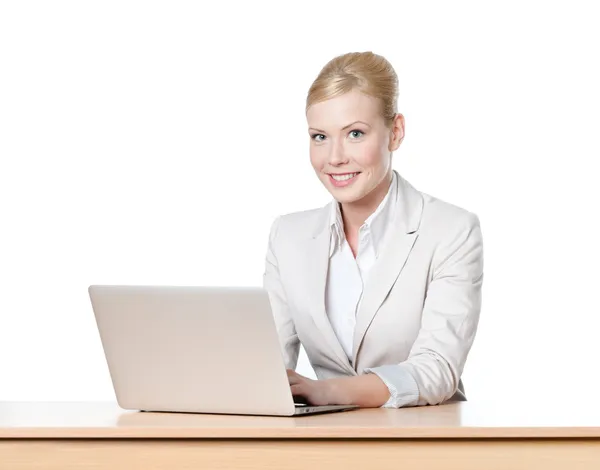 Ung affärskvinna sitter vid ett bord i office med laptop, isloated — Stockfoto