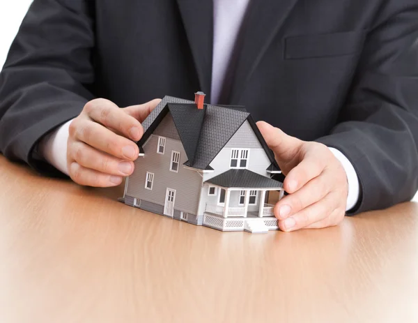 Biznesmen ręce wokół gospodarstwa domowego model architektoniczny — Zdjęcie stockowe