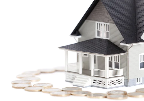 Coins around the house architectural model, isolated — Stock Photo, Image