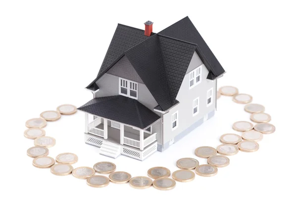 Coins around the home architectural model, isolated — Stock Photo, Image