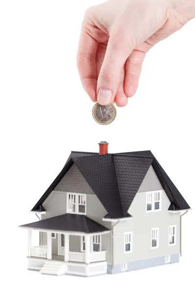 Hand putting coin into house architectural model — Stock Photo, Image
