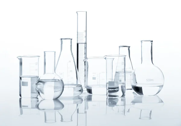 Klasik laboratuvar şişeler berrak bir sıvı ile grup — Stok fotoğraf