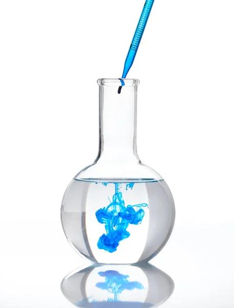 Flask full of clear liquid with a blue reagent — Stock Photo, Image