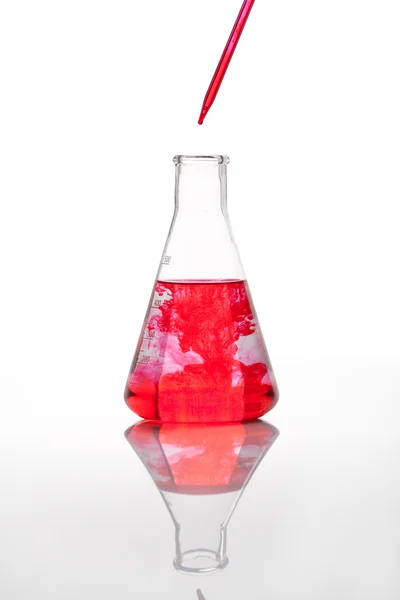 Лабораторная колба с красной жидкостью — стоковое фото
