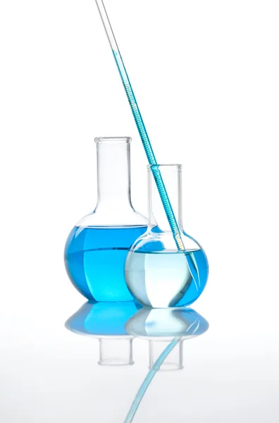 Две лабораторные колбы с голубой жидкостью — стоковое фото