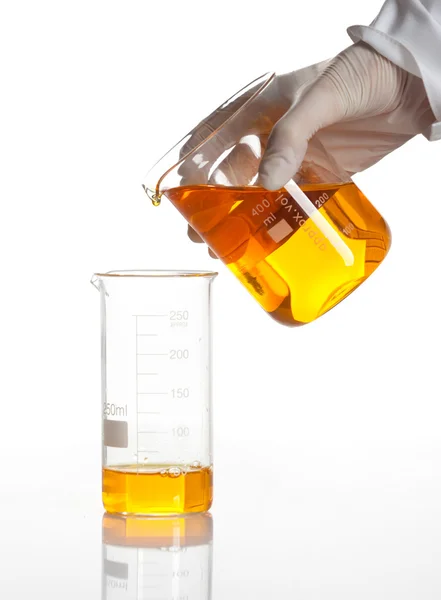 Mano sostiene el frasco para hacer una reacción química —  Fotos de Stock