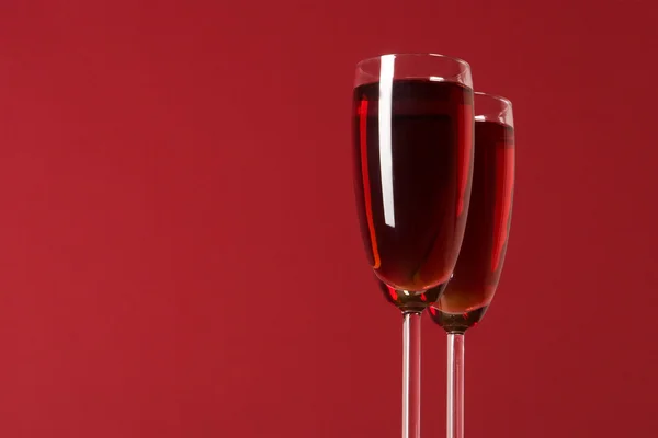 Two wineglasses with wine on the red background — Stock Photo, Image