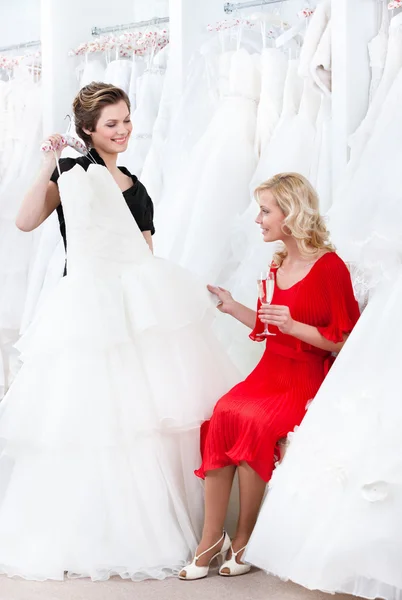 Prodavač navrhuje další šaty nevěsta — Stock fotografie
