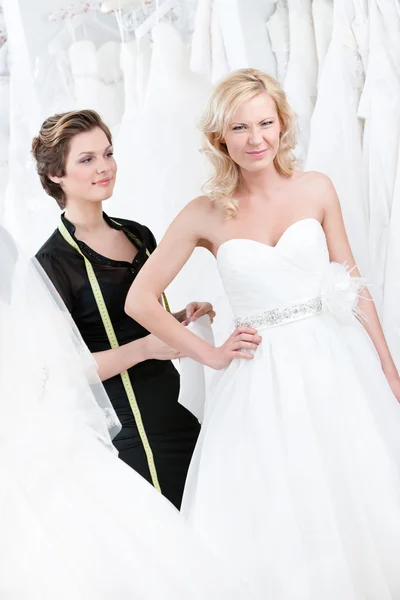 Seamstress measures waist of the dissatisfied bride — Stock Photo, Image