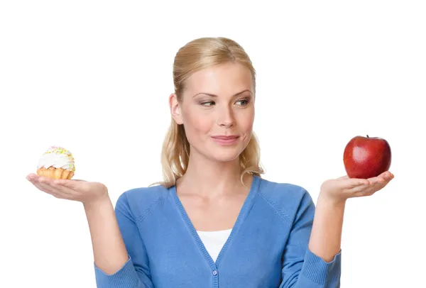 Hübsche Frau trifft die Wahl zwischen Kuchen und Apfel — Stockfoto