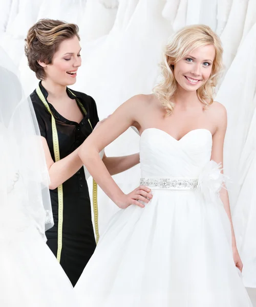 Varrónő állítja be a ruhát a menyasszony — Stock Fotó
