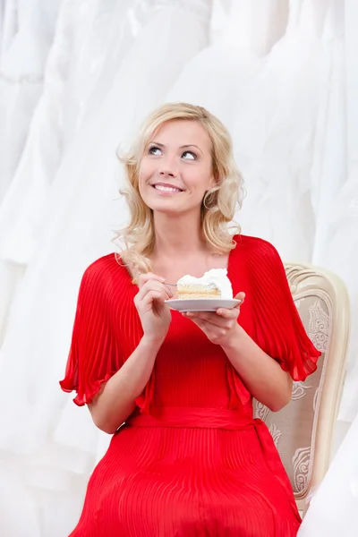 La futura sposa mangia la torta nuziale pensierosamente — Foto Stock