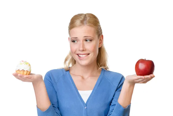Schöne Frau trifft die Wahl zwischen Kuchen und Apfel — Stockfoto